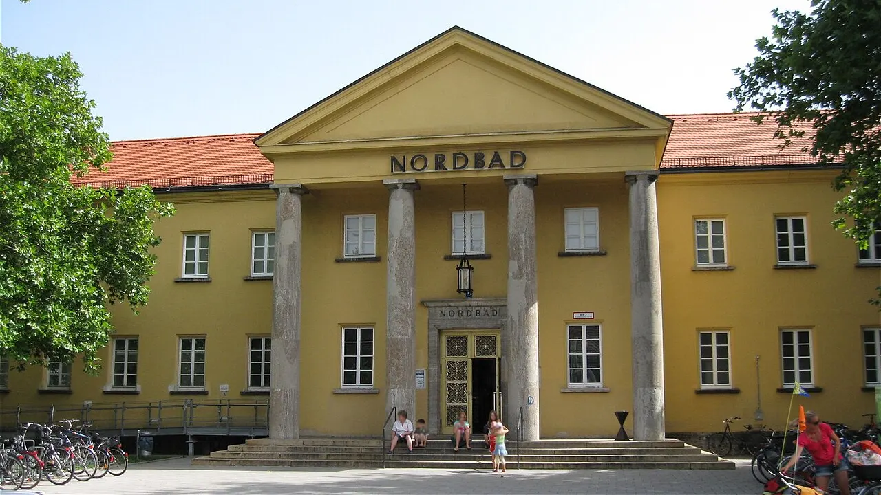 Gelbes Gebäude des Nordbads in München mit Säulenportal und dem Schriftzug Nordbad